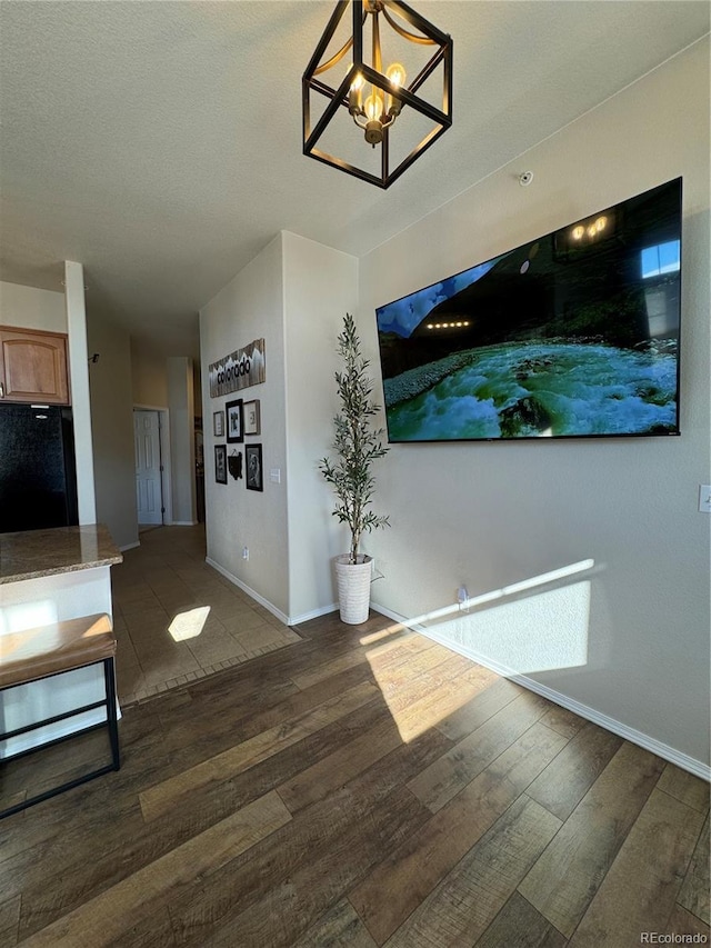 unfurnished living room featuring dark hardwood / wood-style floors, a textured ceiling, and a chandelier