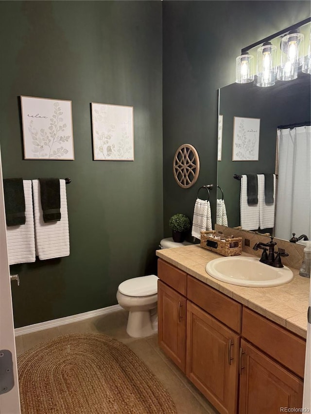 bathroom featuring tile patterned flooring, vanity, and toilet