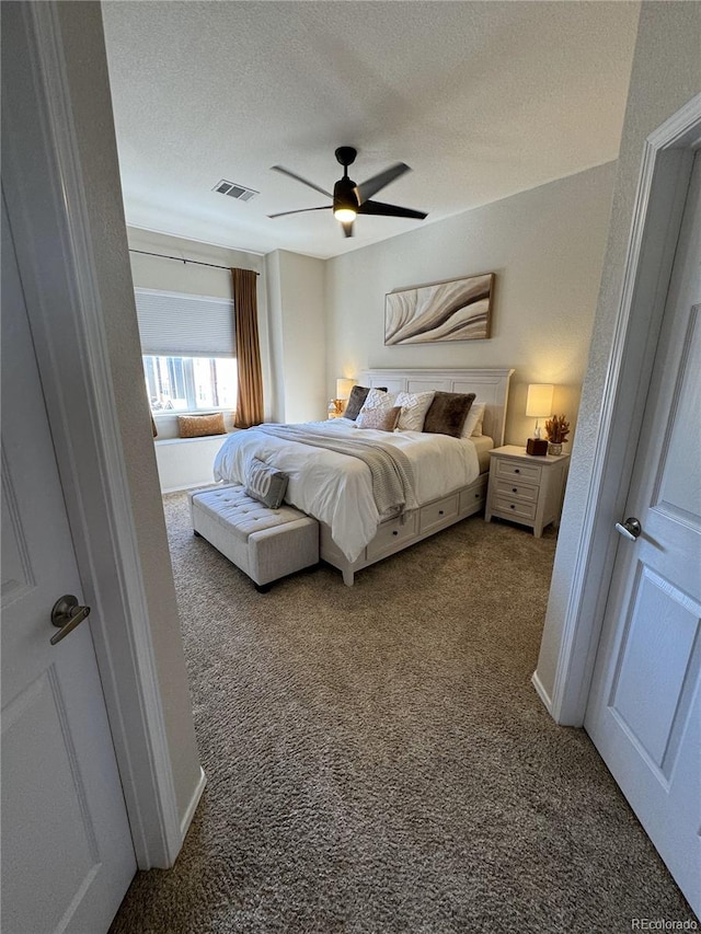 bedroom featuring carpet flooring, ceiling fan, and a textured ceiling