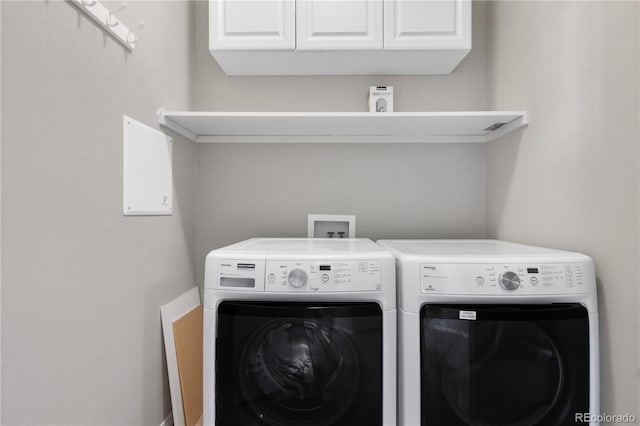 laundry area featuring separate washer and dryer and cabinets