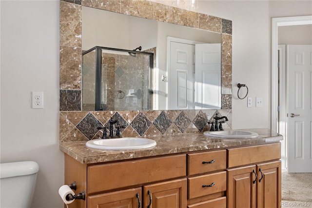 bathroom featuring vanity, backsplash, and a shower with door