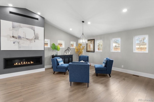 sitting room featuring lofted ceiling, a fireplace, and light hardwood / wood-style flooring