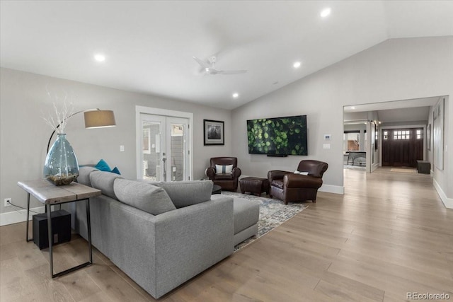 living room with french doors, ceiling fan, lofted ceiling, and light wood-type flooring