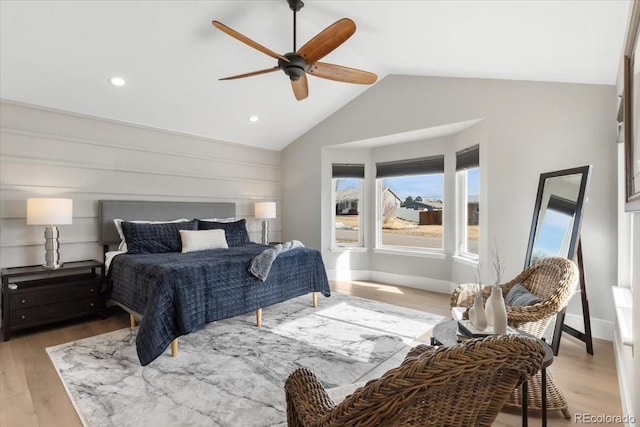 bedroom with ceiling fan, vaulted ceiling, and light hardwood / wood-style flooring