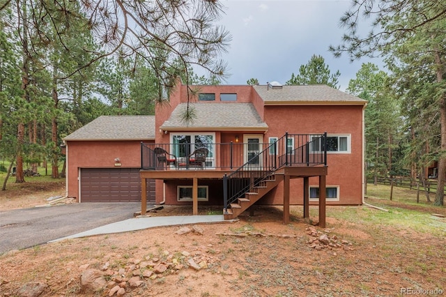 753 Edge Hill Dr, Woodland Park, CO 80863 - back of house with asphalt driveway, a shingled roof, stairway, a deck, and a garage