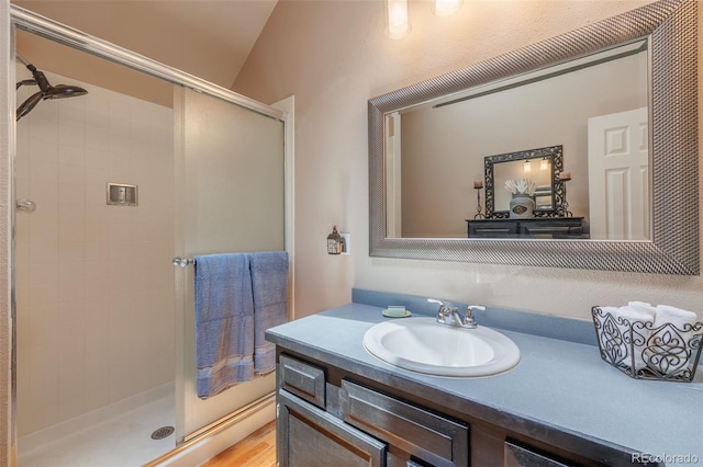 753 Edge Hill Dr, Woodland Park, CO 80863 - bathroom featuring a stall shower, vanity, and vaulted ceiling