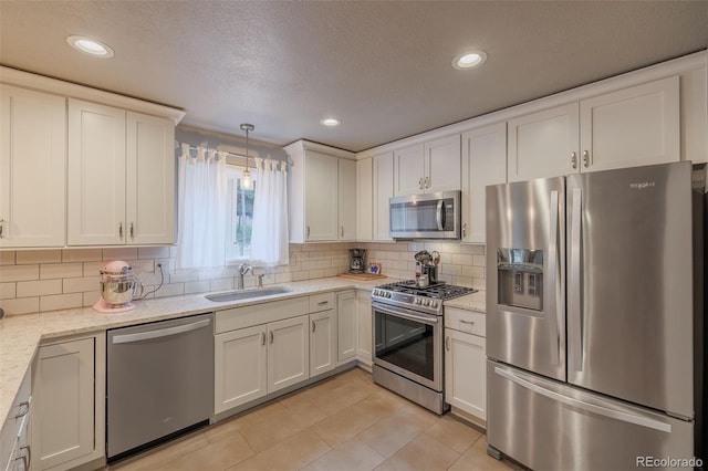 753 Edge Hill Dr, Woodland Park, CO 80863 - kitchen featuring stainless steel appliances, light tile patterned flooring, white cabinetry, tasteful backsplash, and light stone counters