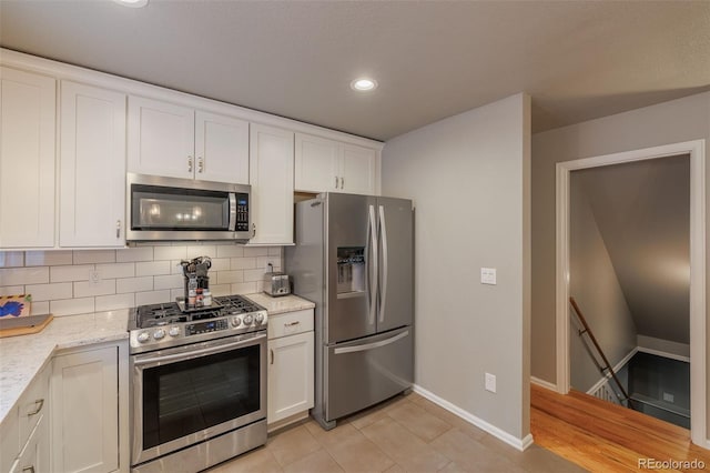 753 Edge Hill Dr, Woodland Park, CO 80863 - kitchen featuring appliances with stainless steel finishes, tasteful backsplash, white cabinetry, recessed lighting, and light stone counters