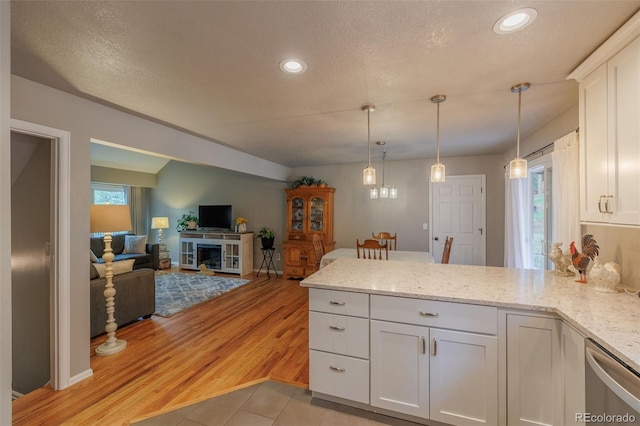 753 Edge Hill Dr, Woodland Park, CO 80863 - kitchen with a peninsula, white cabinets, dishwasher, recessed lighting, and hanging light fixtures