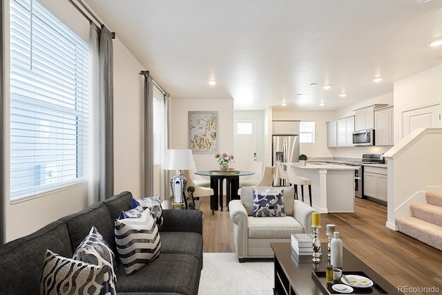 living room featuring light wood-type flooring and a textured ceiling