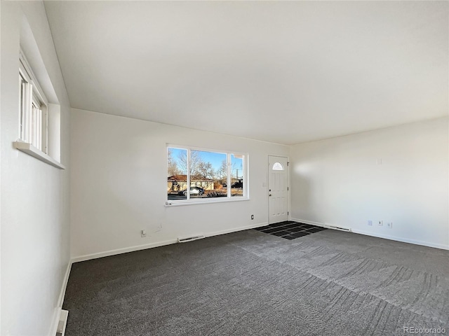 unfurnished room with dark colored carpet