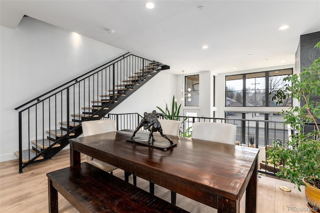dining area with recessed lighting, light wood-style flooring, and stairs