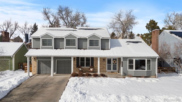 view of front of house featuring a porch, brick siding, driveway, and an attached garage