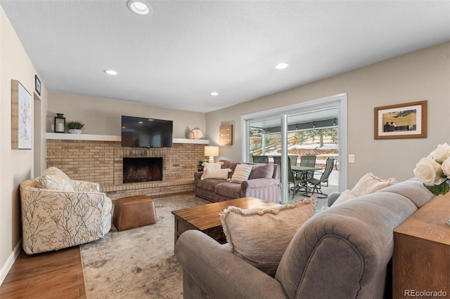 living room with baseboards, a fireplace, wood finished floors, and recessed lighting