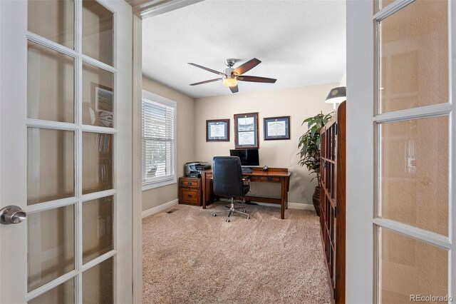 office area featuring carpet, baseboards, a ceiling fan, and french doors