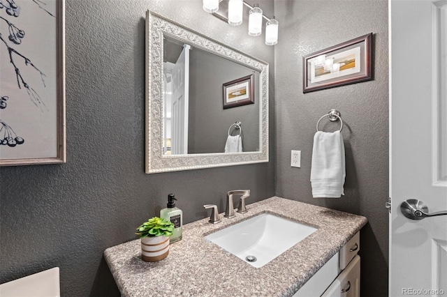 bathroom with vanity and a textured wall