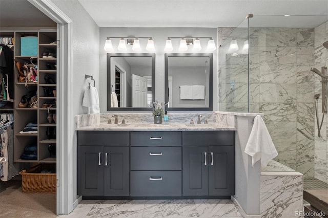 bathroom with a sink, marble finish floor, a spacious closet, a marble finish shower, and double vanity