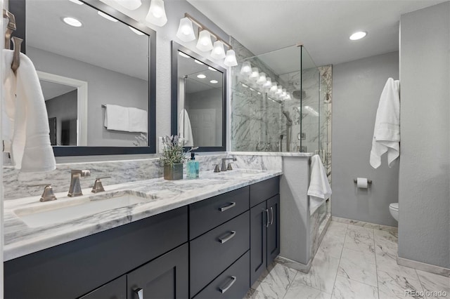 bathroom featuring marble finish floor, a sink, a marble finish shower, and double vanity