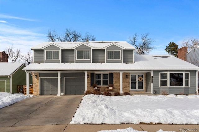 traditional home with driveway, a garage, a porch, and brick siding