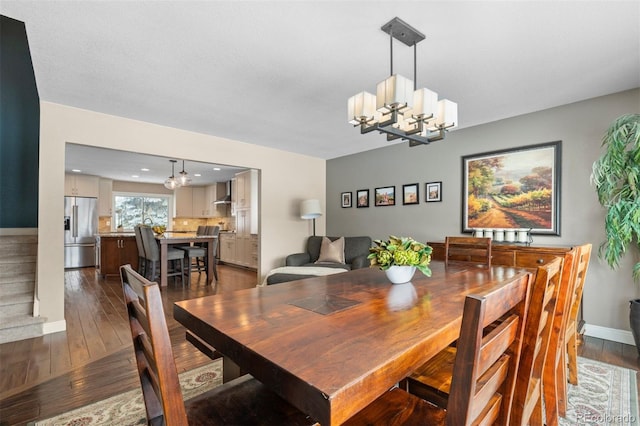 dining space with an inviting chandelier, baseboards, and dark wood-type flooring