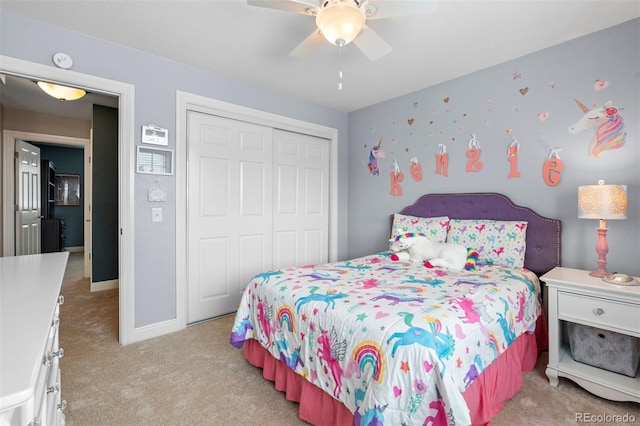 bedroom featuring light carpet, a closet, a ceiling fan, and baseboards