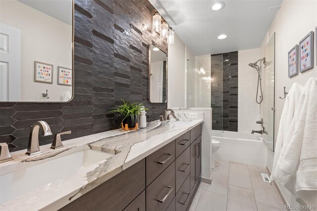 bathroom with tasteful backsplash, a sink, toilet, and tile patterned floors