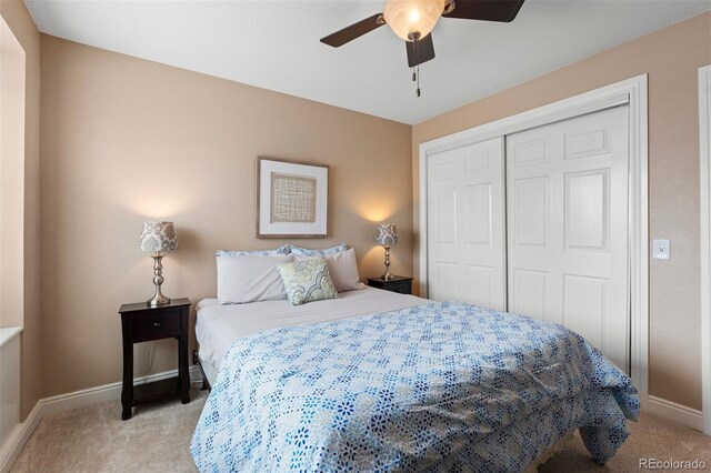 bedroom featuring light carpet, baseboards, and a closet