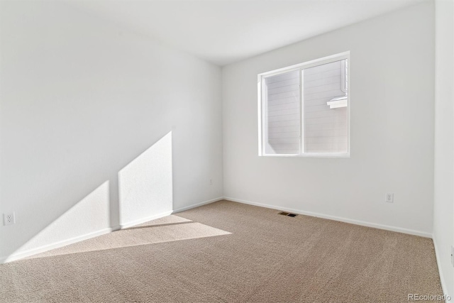 unfurnished room featuring light carpet