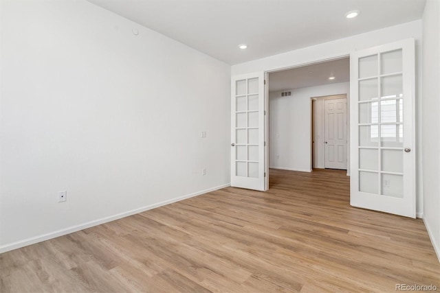 unfurnished room with french doors and light wood-type flooring