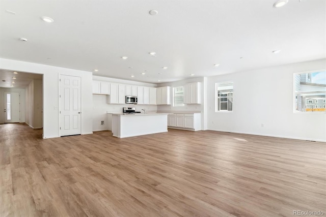 unfurnished living room with a wealth of natural light and light hardwood / wood-style flooring