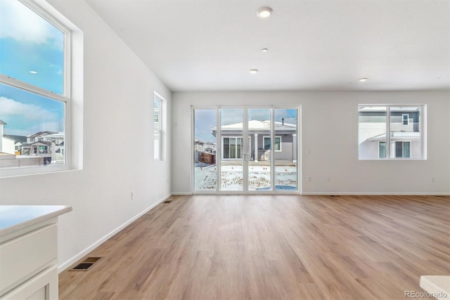 unfurnished living room featuring light hardwood / wood-style flooring and a wealth of natural light