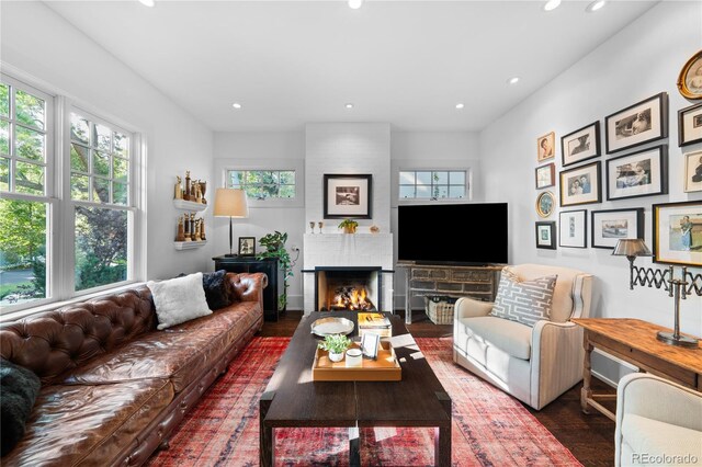 living room featuring a large fireplace, dark wood-style floors, and recessed lighting