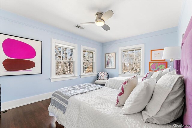 bedroom with dark wood-style flooring, visible vents, ceiling fan, and baseboards