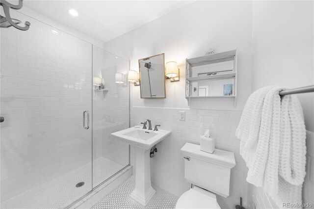 full bath featuring a stall shower, tile walls, toilet, and tile patterned floors