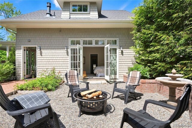 exterior space featuring an outdoor fire pit, roof with shingles, and a patio area