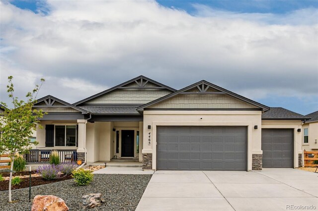 4465 Mesa Top Dr, Monument, CO 80132 - craftsman house featuring an attached garage, a porch, stone siding, and concrete driveway