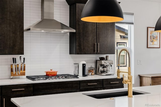 4465 Mesa Top Dr, Monument, CO 80132 - kitchen with wall chimney range hood, stainless steel gas cooktop, backsplash, light countertops, and dark brown cabinetry