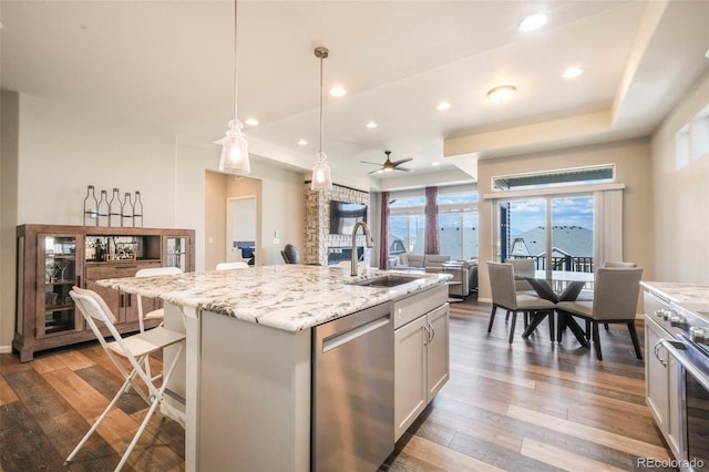 6362 Lythmore Grv, Colorado Springs, CO 80927 - kitchen featuring stainless steel dishwasher, a sink, open floor plan, wood finished floors, and recessed lighting