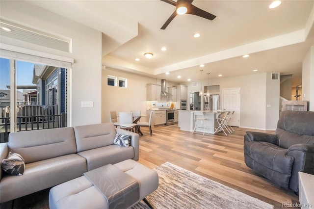6362 Lythmore Grv, Colorado Springs, CO 80927 - living area with a tray ceiling, light wood-type flooring, recessed lighting, a ceiling fan, and baseboards