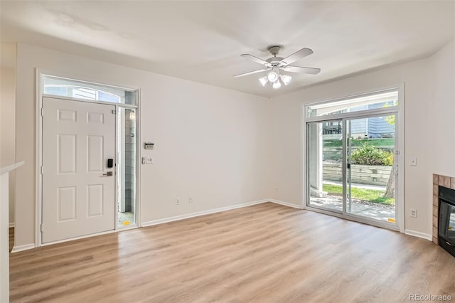 8500 E Jefferson Unit 3C, Denver, CO 80237 - foyer with light wood-style flooring, a tile fireplace, baseboards, and a ceiling fan