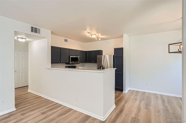 8500 E Jefferson Unit 3C, Denver, CO 80237 - kitchen featuring appliances with stainless steel finishes, light wood-style floors, light countertops, and a peninsula