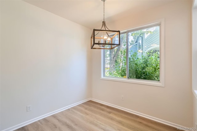 8500 E Jefferson Unit 3C, Denver, CO 80237 - unfurnished dining area with a chandelier, baseboards, and light wood-type flooring