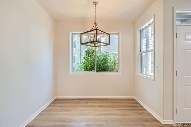 8500 E Jefferson Unit 3C, Denver, CO 80237 - unfurnished dining area with a chandelier, light wood-style flooring, and baseboards