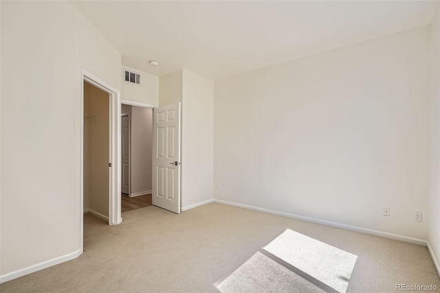 8500 E Jefferson Unit 3C, Denver, CO 80237 - unfurnished bedroom featuring light carpet, baseboards, and a walk in closet