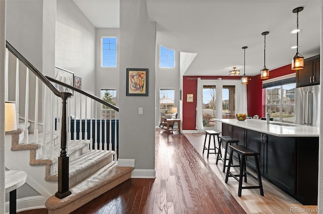 entryway with light wood-style flooring, a healthy amount of sunlight, baseboards, and stairs