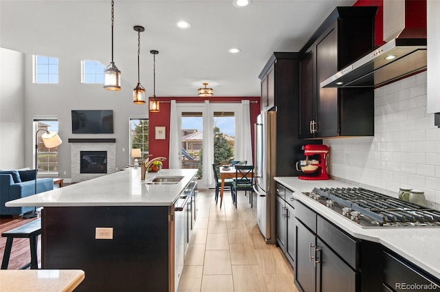 kitchen featuring stainless steel appliances, a wealth of natural light, tasteful backsplash, and wall chimney exhaust hood
