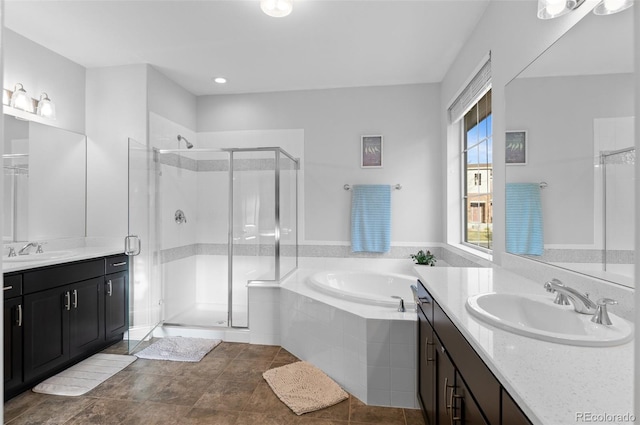 bathroom with a sink, a stall shower, and a garden tub