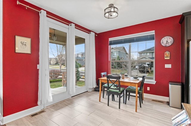 dining room with a wealth of natural light, visible vents, and baseboards