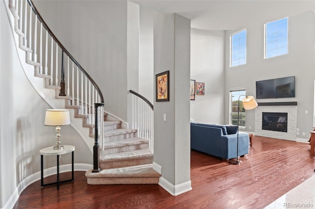 staircase with a healthy amount of sunlight, baseboards, and wood finished floors