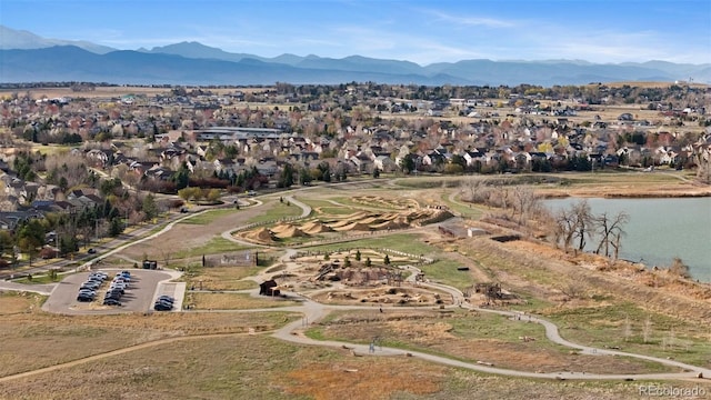 drone / aerial view featuring a water and mountain view and a residential view